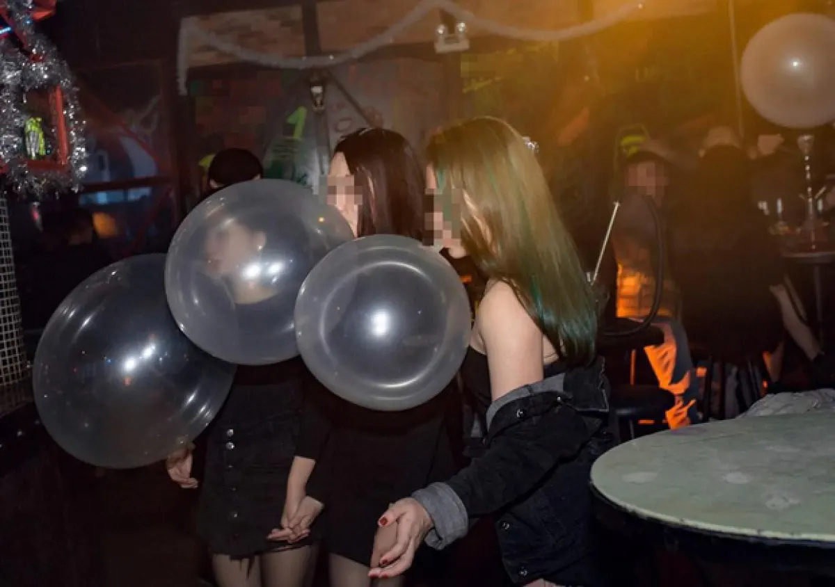 Những bạn trẻ ăn mặt sành điệu đang “tận hưởng” những quả bóng cười trong một hộp đêm